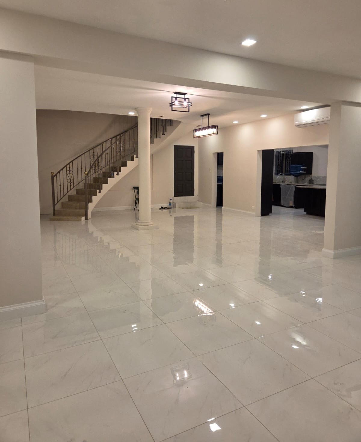 Main living area with curved staircase and marble tiled floors