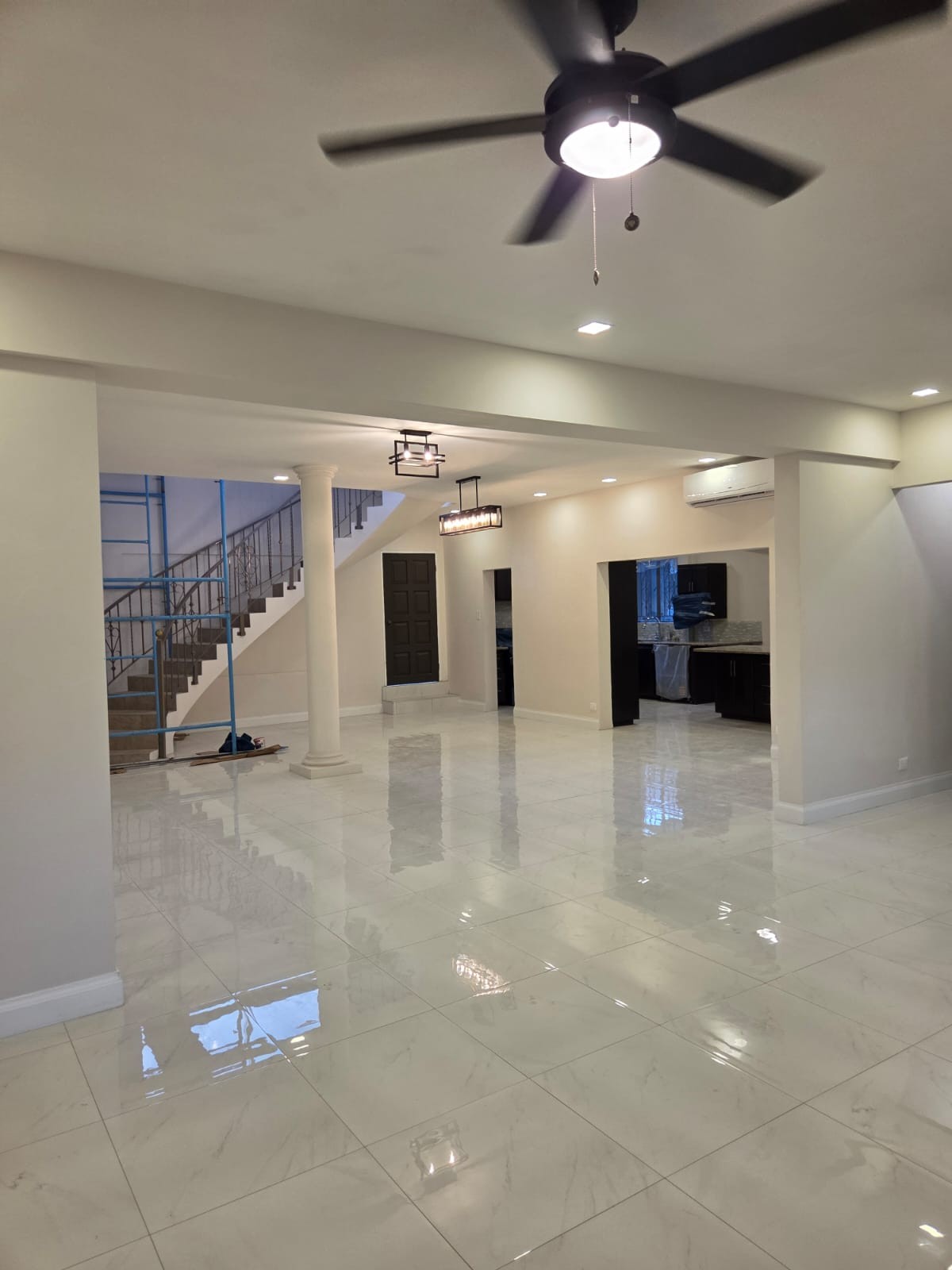 Expansive interior view showing the staircase, column and kitchen opening